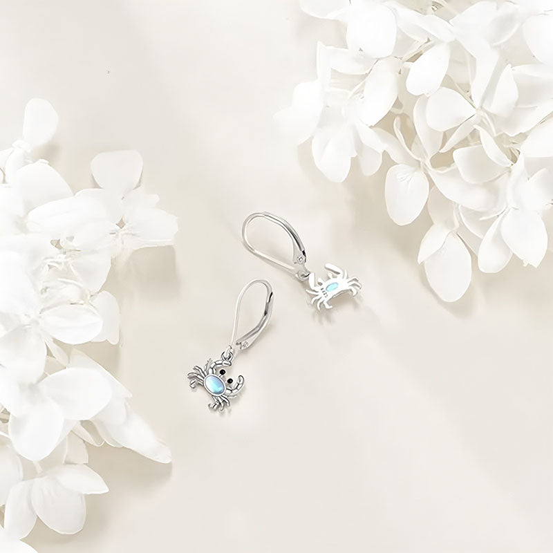 Origsoul 925 silver crab earrings with light blue accents on a white floral background