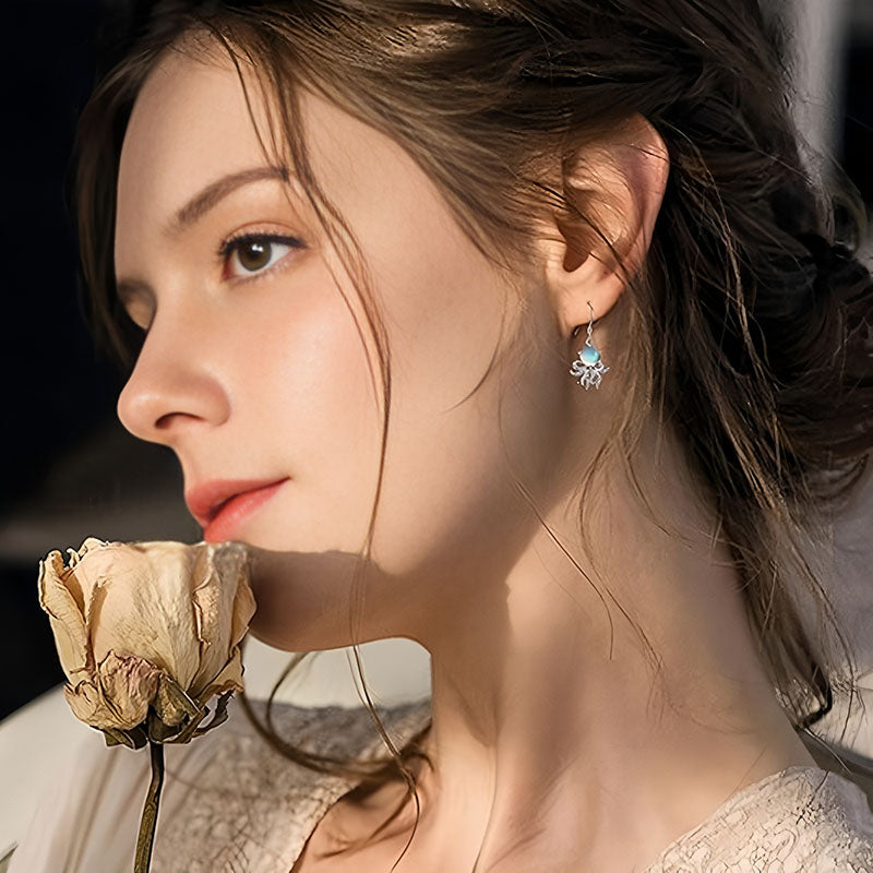 Elegant model wearing 925 silver octopus earrings showcasing a stunning design with blue accents
