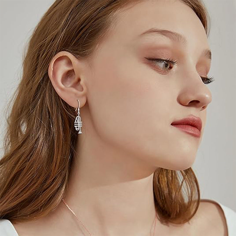 Origsoul 925 silver trumpet earrings worn by a woman with natural makeup and light brown hair