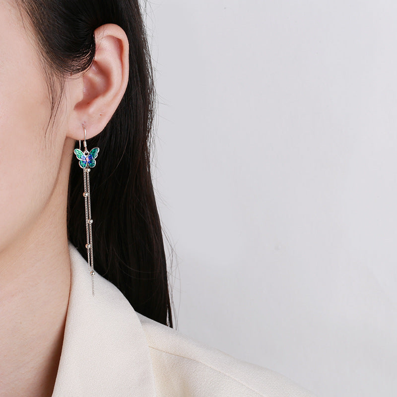 Origsoul butterfly tassel earrings with colorful butterfly and long silver tassels worn on ear