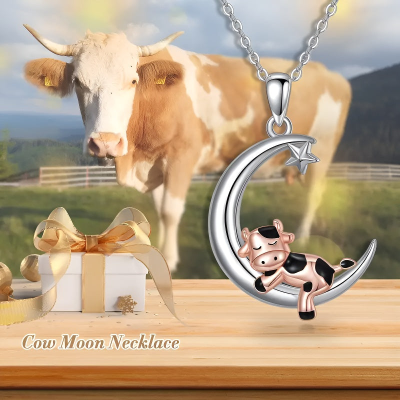Cartoon cow moon pendant necklace featuring a cute cow resting on a crescent moon against a scenic backdrop