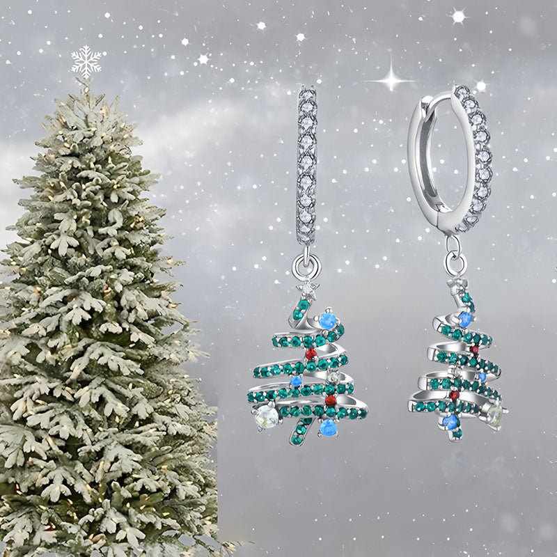Origsoul Christmas tree hoop earrings with green and blue gemstones on silver hoops against a snowy winter background