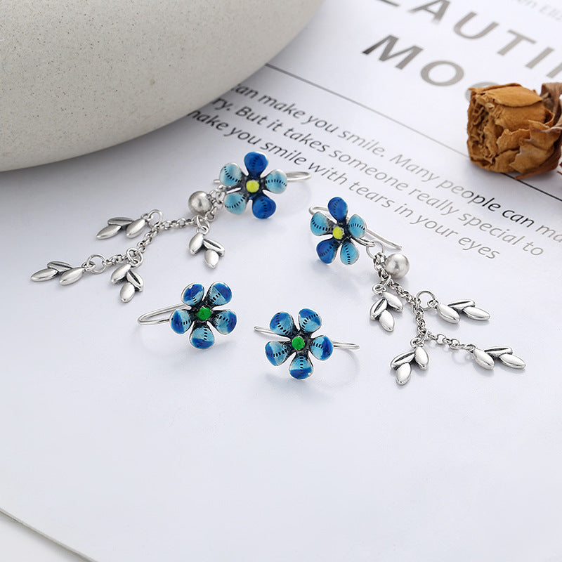 Origsoul daisy tassel earrings with blue flower petals and silver leaf charms on white background