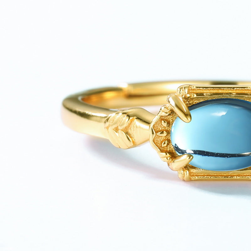 Elegant blue topaz engagement ring by Origsoul with gold band and detailed prong setting