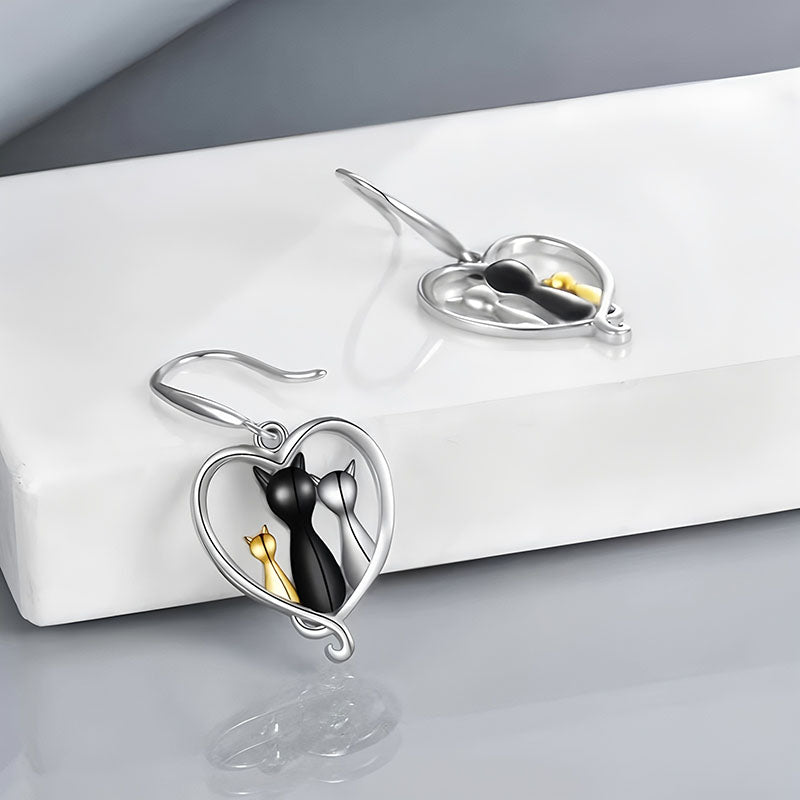 Origsoul family cat earrings featuring silver heart frames with black and gold cat silhouettes