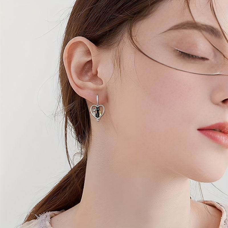 Origsoul family cat earrings in silver with heart-shaped design worn on ear