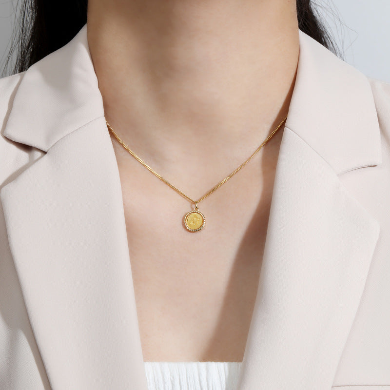 Origsoul gold sun charm jewelry necklace worn with a beige blazer and white top