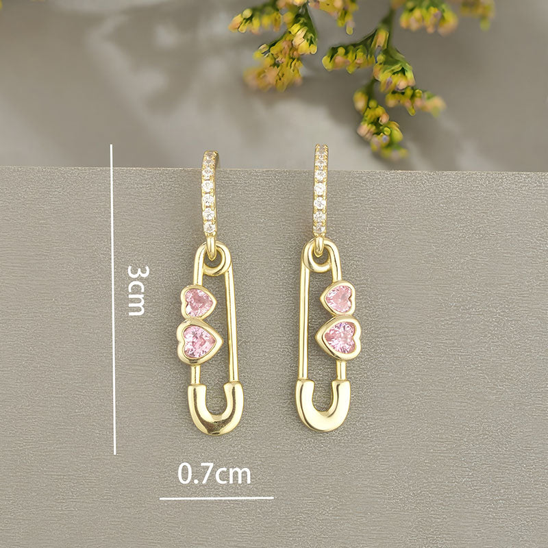 Origsoul gold heart shaped safety pin earrings with pink heart gemstones and diamond hoop accents