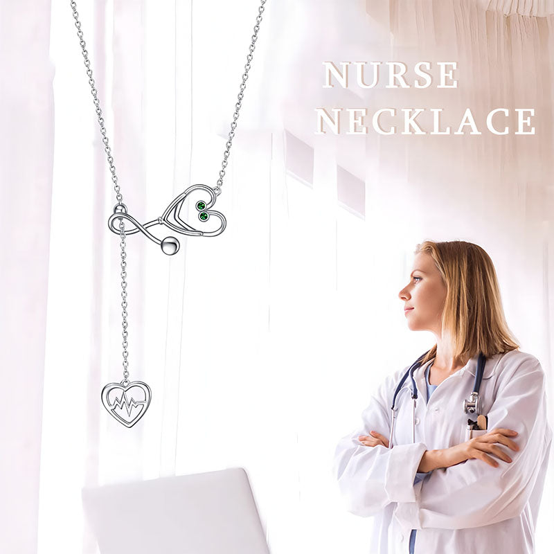 Origsoul infinity heart stethoscope necklace featuring a heart-shaped stethoscope pendant with green gemstones