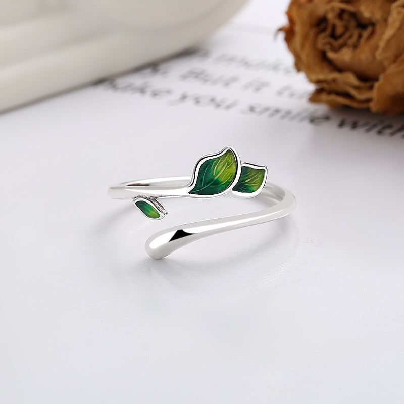 Origsoul delicate silver olive leaf ring with green enamel detailing on a white surface