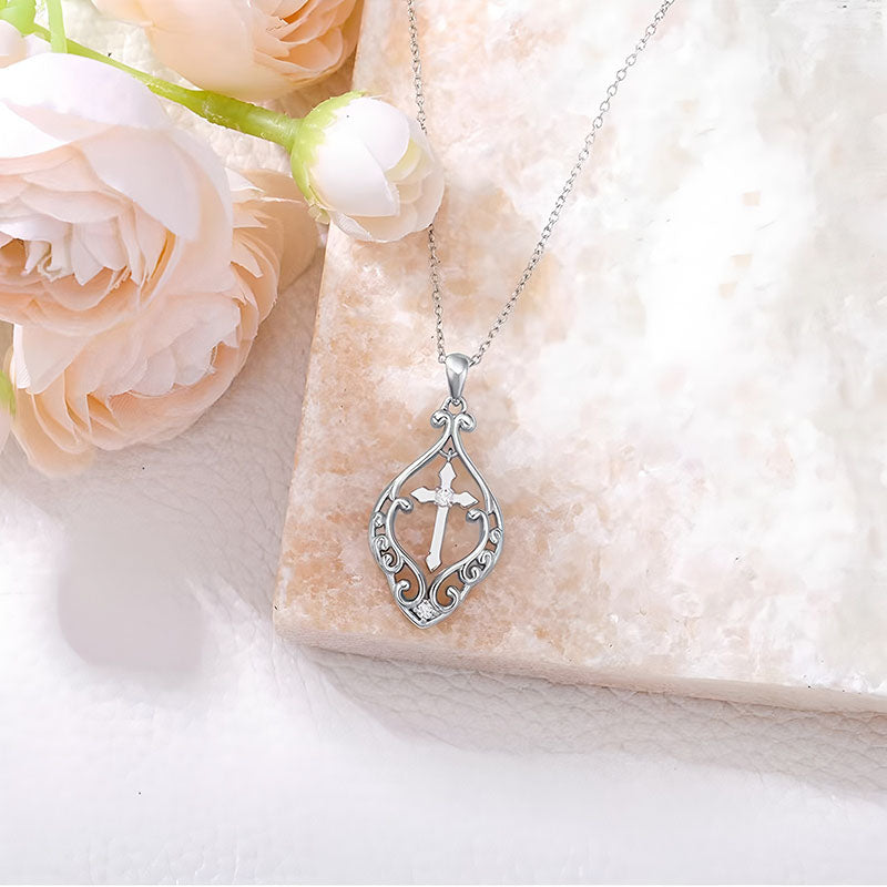 Origsoul silver ornate heart cross necklace with intricate filigree design displayed on marble slab
