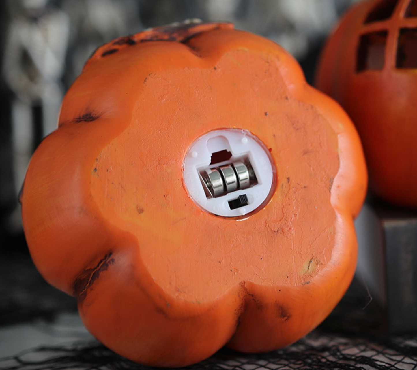 Bottom view of Origsoul resin haunted house pumpkin home decoration showing battery compartment