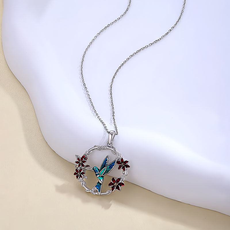 Origsoul hummingbird floral necklace with blue enamel hummingbird and red flower accents on silver chain