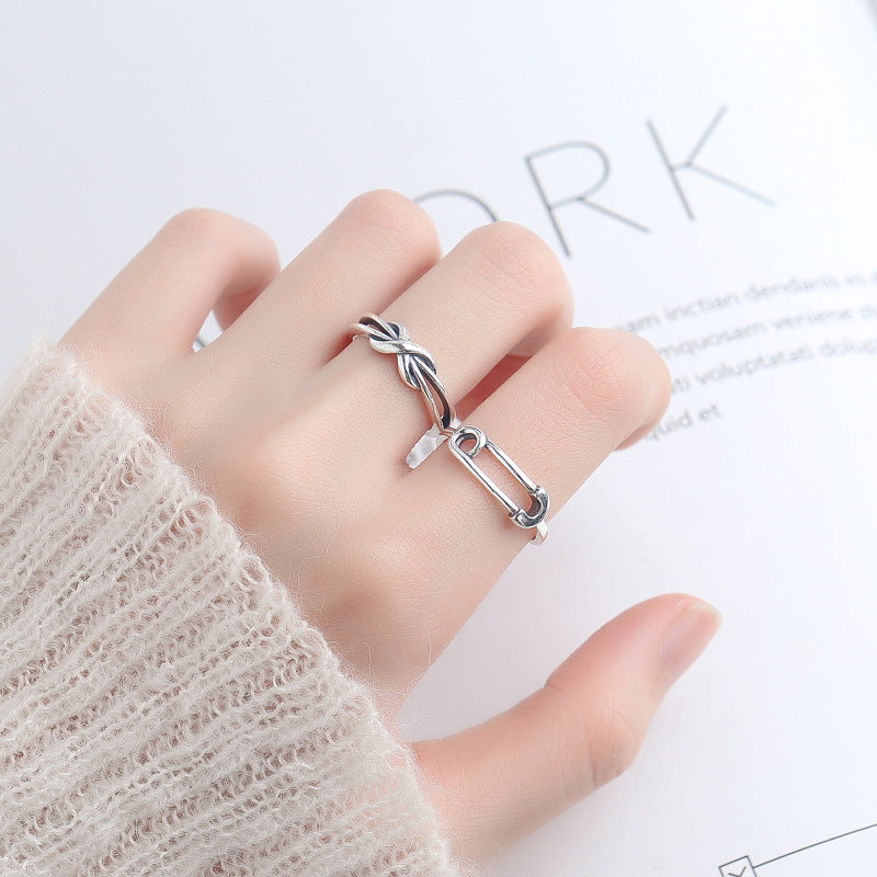 Origsoul silver safety pin ring worn on finger with cozy beige knit sweater background