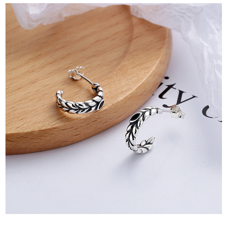 Origsoul silver wheat hoop earrings featuring detailed woven design on a wooden surface