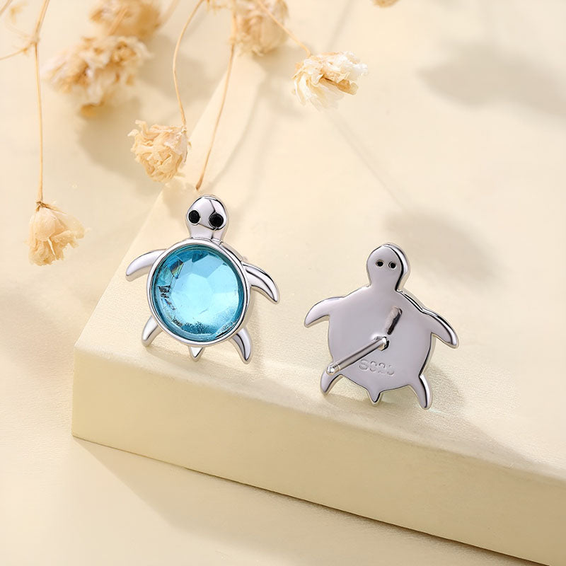 Cute sterling silver turtle earrings with a blue gemstone, perfect for ocean lovers and nature enthusiasts