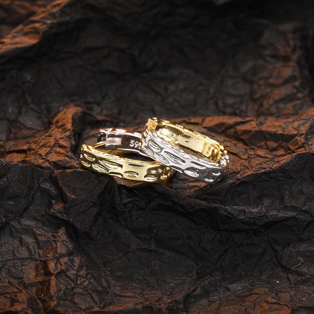 Origsoul unique gold hoop earrings with textured pattern displayed on crumpled black fabric