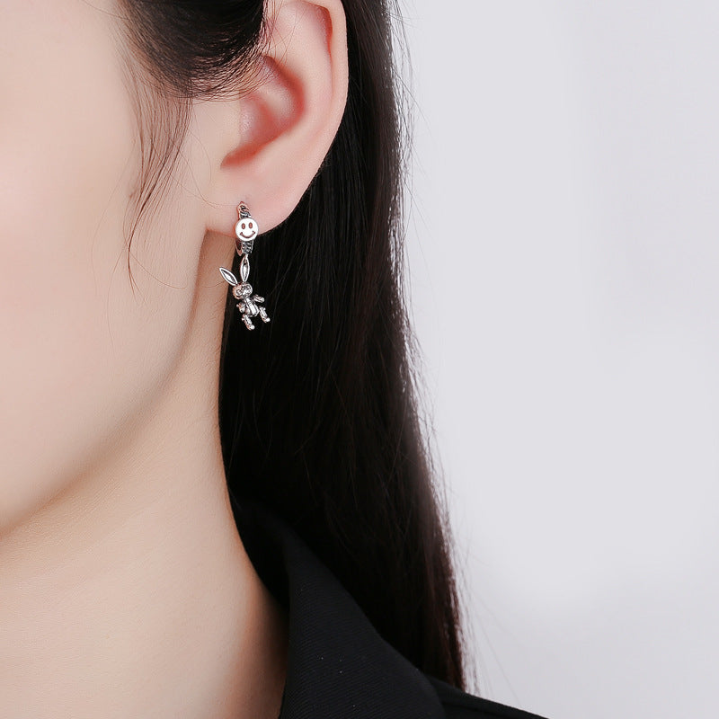 Origsoul cute rabbit charm earrings worn on a woman's ear with a minimalist white background