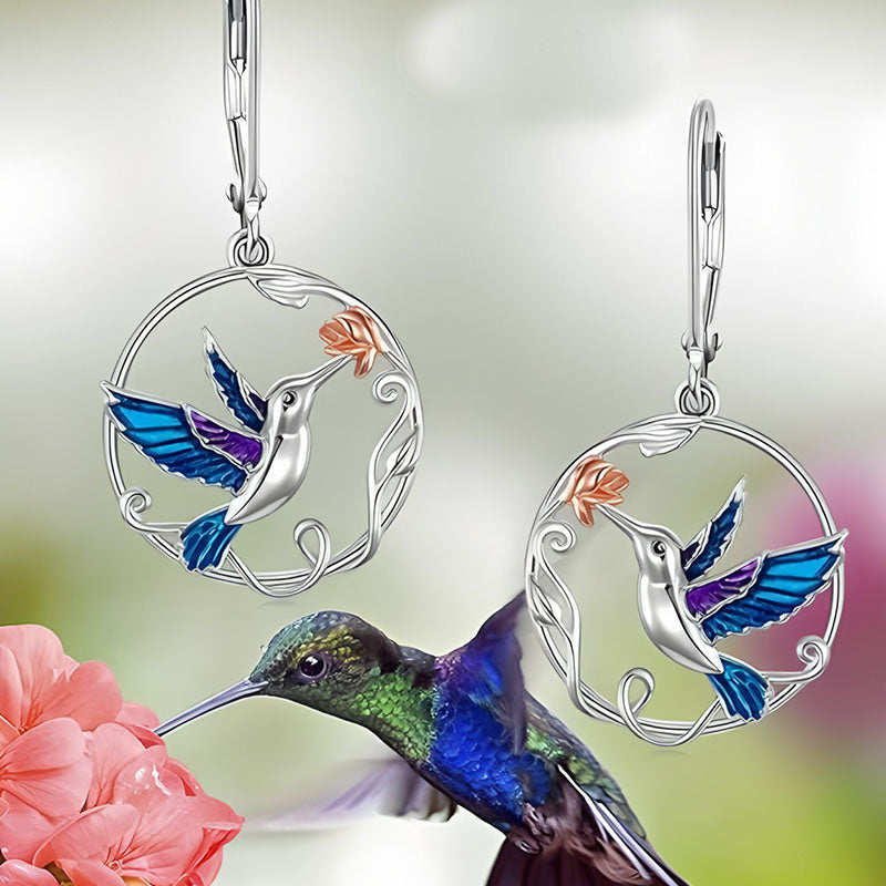 Origsoul handcrafted bird drop earrings featuring blue and purple enamel hummingbirds with flower accents