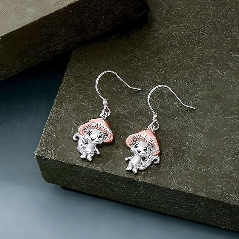 Origsoul whimsical mushroom charm earrings with silver and rose gold tones on textured surface