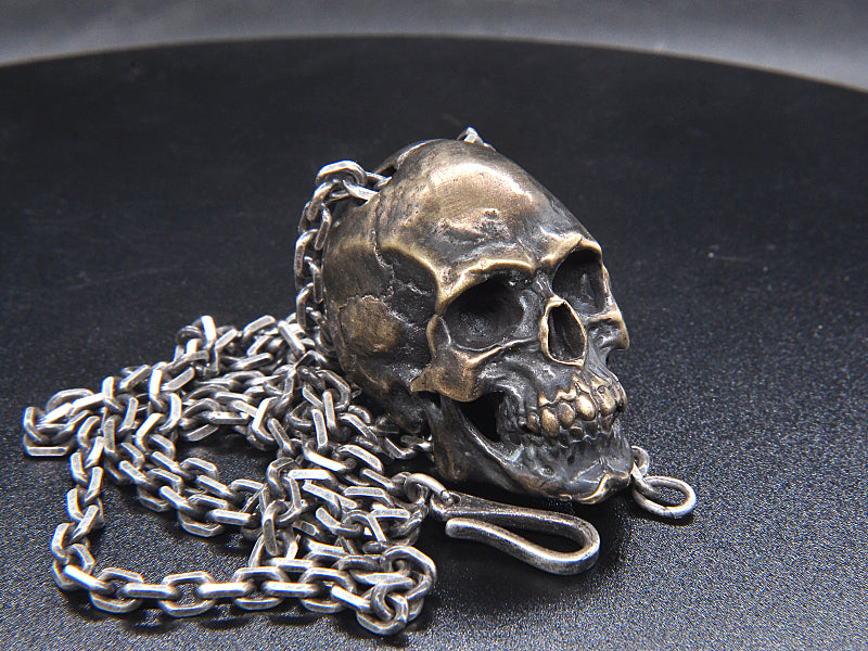 Origsoul artisan skull pendant for men with detailed silver chain on dark surface