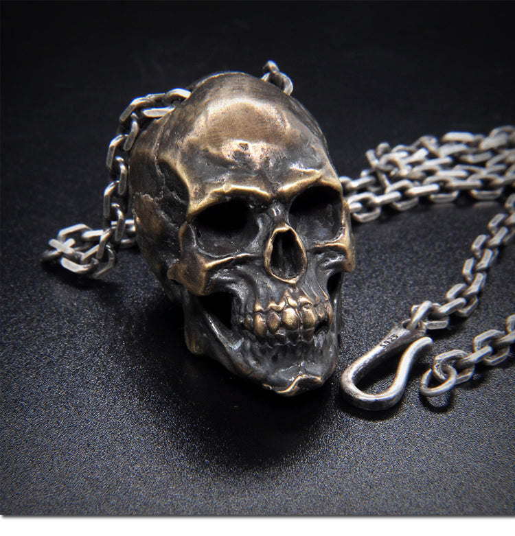 Origsoul artisan skull pendant for men in antique silver with detailed chain on black surface