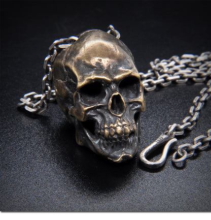 Origsoul artisan skull pendant for men in antique silver with detailed chain on black surface