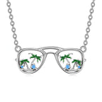 Origsoul silver beach sunglasses necklace with palm trees and blue gem accents on chain