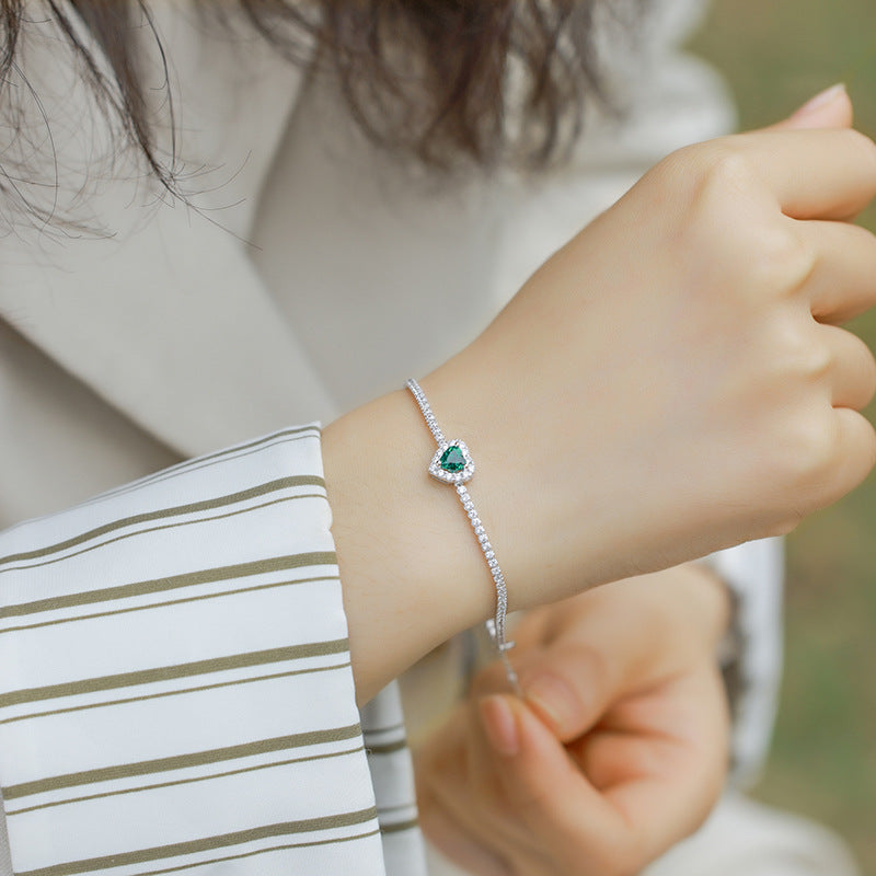 Origsoul delicate bracelet with emerald heart-shaped stone and diamond accents on wrist