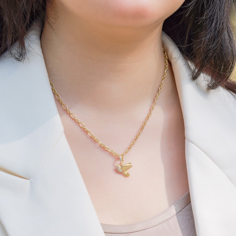 Origsoul sterling silver necklace with gold chain and bird pendant worn on neck