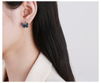 Origsoul butterfly earrings for women in blue worn on ear with dark hair and white top