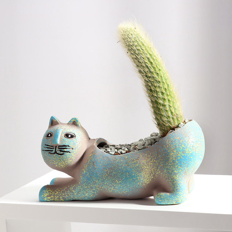 Origsoul cat shaped succulent planter in blue with a tall cactus plant inside on a white surface