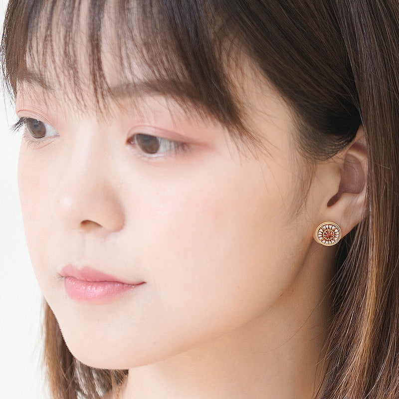 Origsoul Chanel vintage earrings worn by woman showing round gold-toned design with detailed center