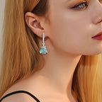 Origsoul Christmas tree hoop earrings with green and red accents worn by a woman