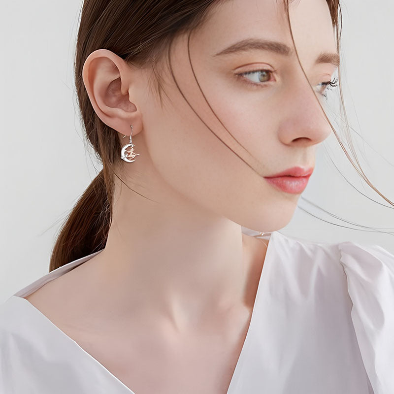 Origsoul crescent moon dangle earrings worn by woman with white blouse and soft makeup