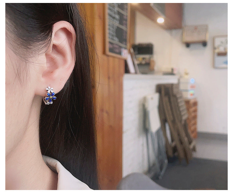 Origsoul birthflower daisy hoop earrings for women with blue floral design on ear