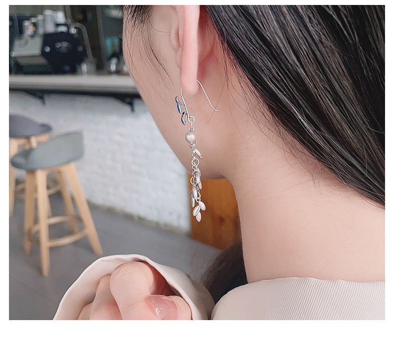 Origsoul daisy tassel earrings worn on ear with delicate flower and chain details