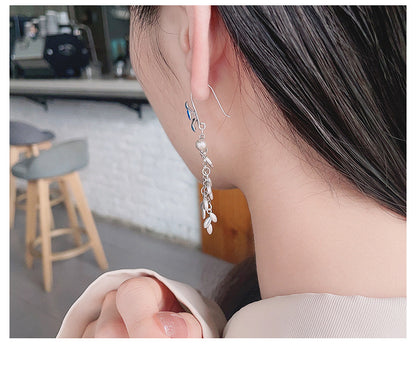 Origsoul daisy tassel earrings worn on ear with delicate flower and chain details