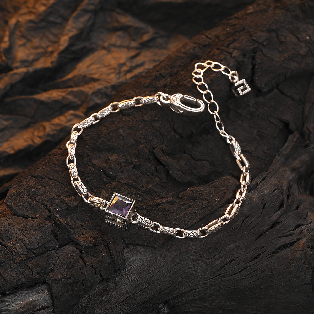 Origsoul designer embossed chain bracelet with a square purple gemstone on dark textured background