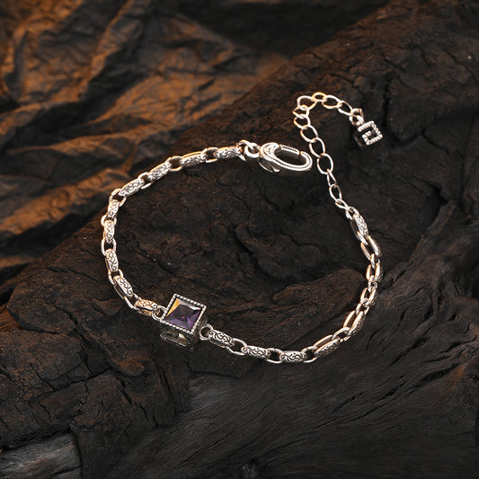 Origsoul designer embossed chain bracelet with a square purple gemstone on dark textured background
