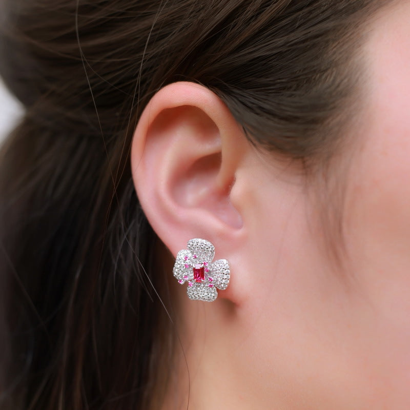 Origsoul earrings diamond stud earrings with pink center stone and surrounding small diamonds on ear