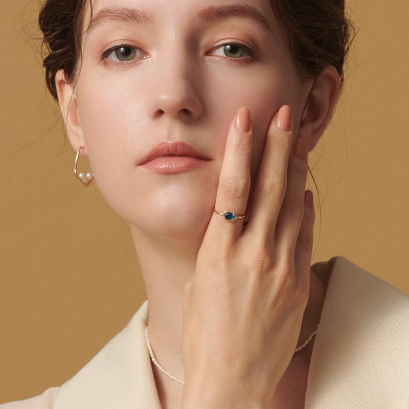 Elegant blue topaz engagement ring on woman’s hand showcasing Origsoul jewelry craftsmanship