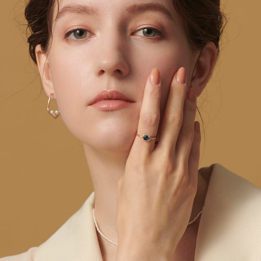 Elegant blue topaz engagement ring on woman’s hand showcasing Origsoul jewelry craftsmanship
