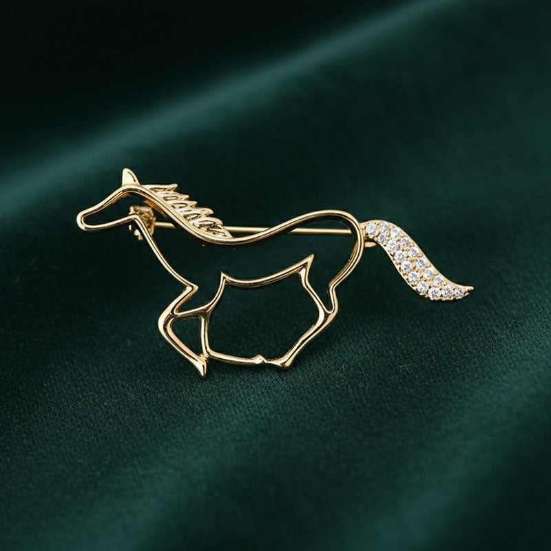 Origsoul elegant horse head brooch in gold with rhinestone tail detail on dark green fabric