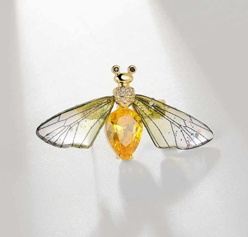Elegant nature-inspired brooch featuring a butterfly design with yellow gemstone and intricate wing details