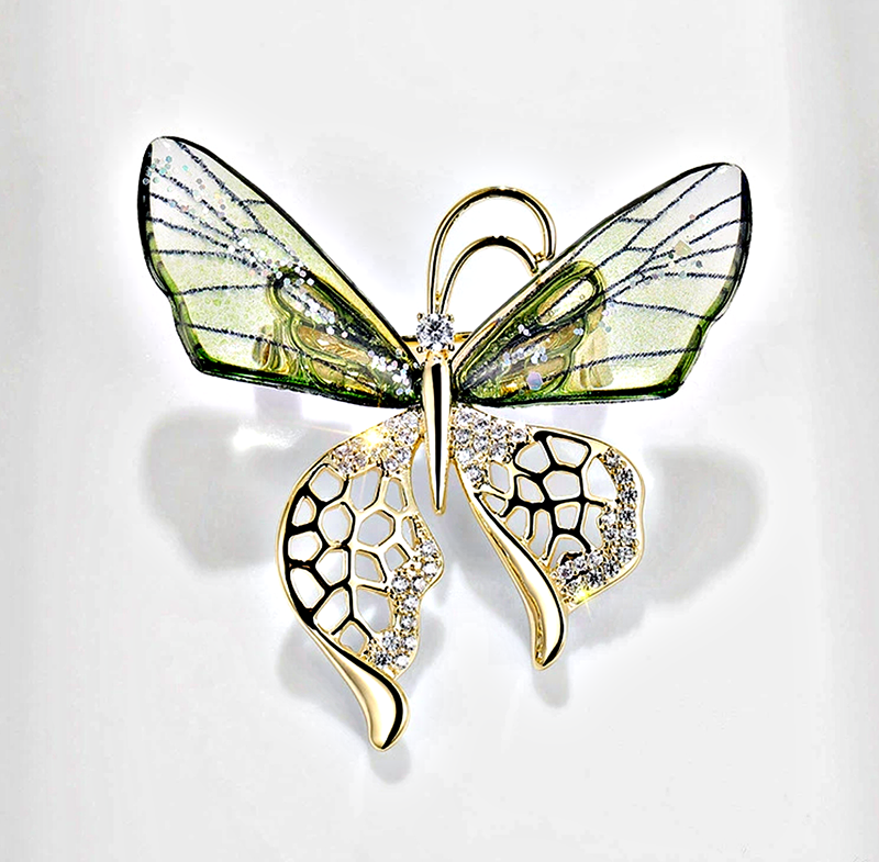 Elegant nature-inspired brooch featuring a butterfly design with green accents and sparkling details