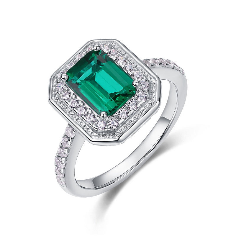 Origsoul emerald cut-engagement ring with a green center gemstone and diamond halo on silver band
