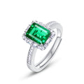 Origsoul emerald cut-engagement ring with a vibrant green center stone and diamond accents on a silver band