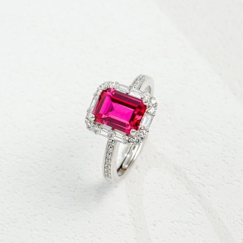 Origsoul emerald cut-engagement ring with a vibrant pink center stone and diamond halo on silver band