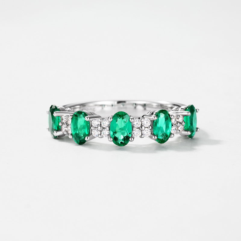 Origsoul emerald engagement ring cut with oval green gemstones and small clear diamonds on silver band